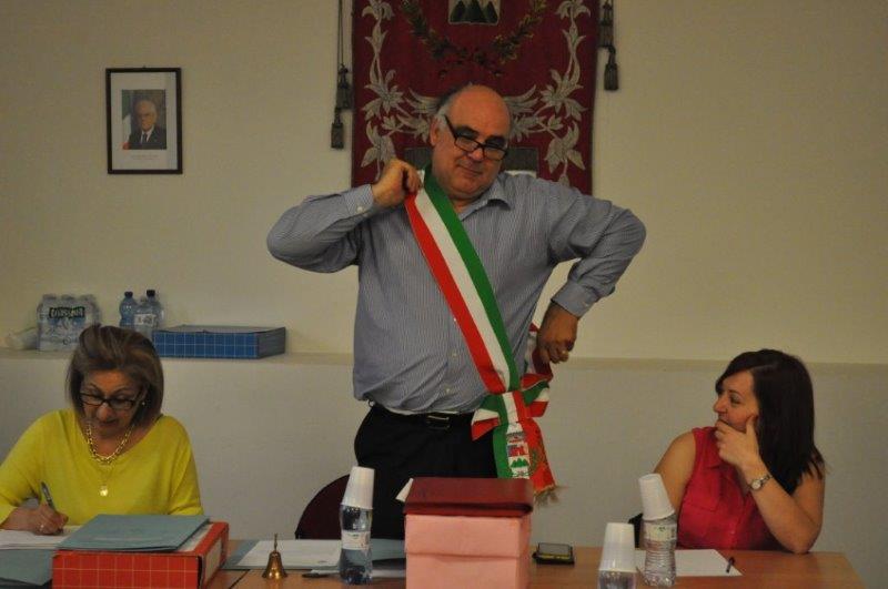 Giancarlo Aldeghi indossa la fascia tricolore fra Ileana Armillotta ( in rosso) e la Segretaria comunale